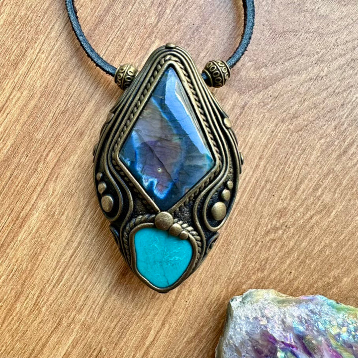 Necklace with a decorative pendant featuring a blue stone on a wooden surface.