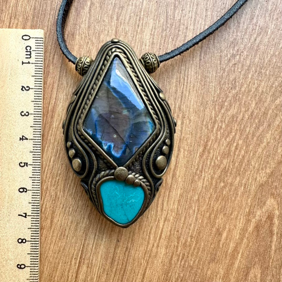 Handmade clay crystal necklace on a wooden surface next to a ruler