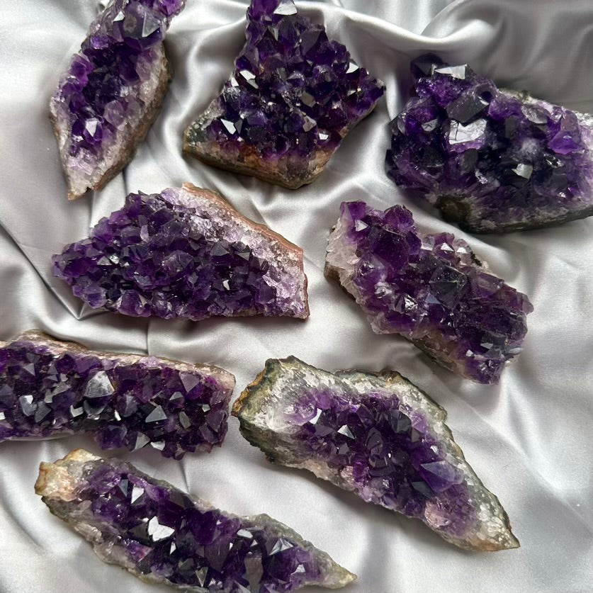 Amethyst crystal clusters on a white fabric background