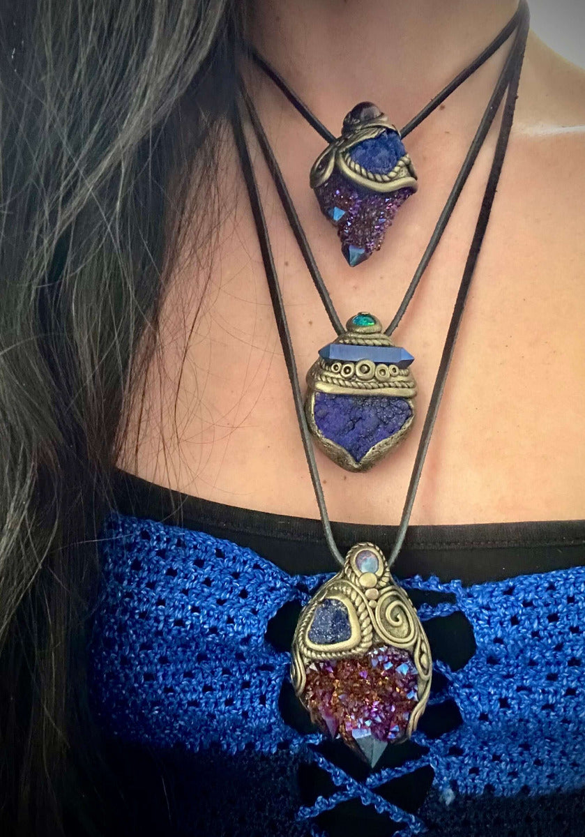 A person wears three Cobalt Aura Quartz Crystal Necklaces