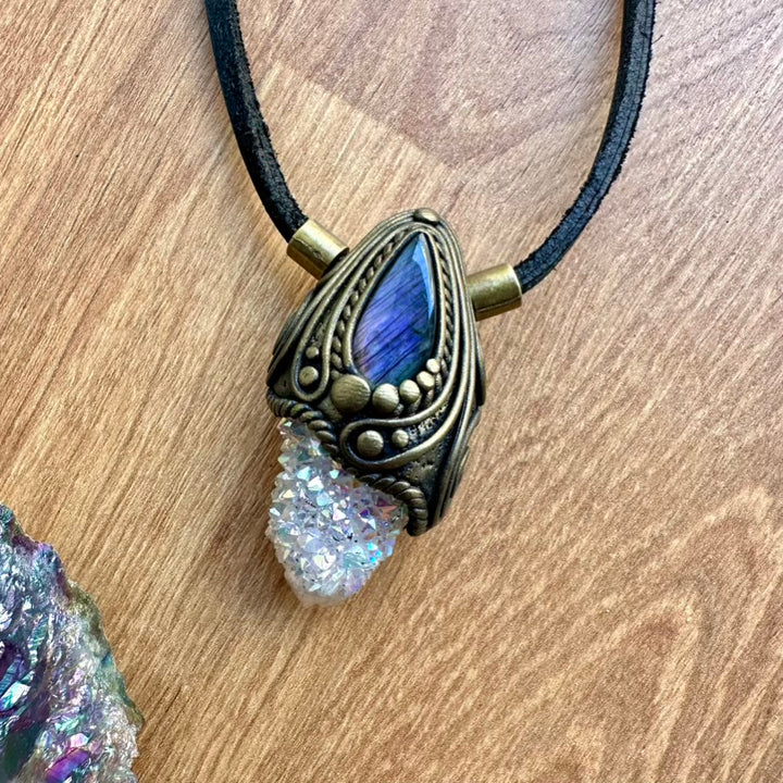 Necklace with a blue gemstone and gold pendant on a wooden surface