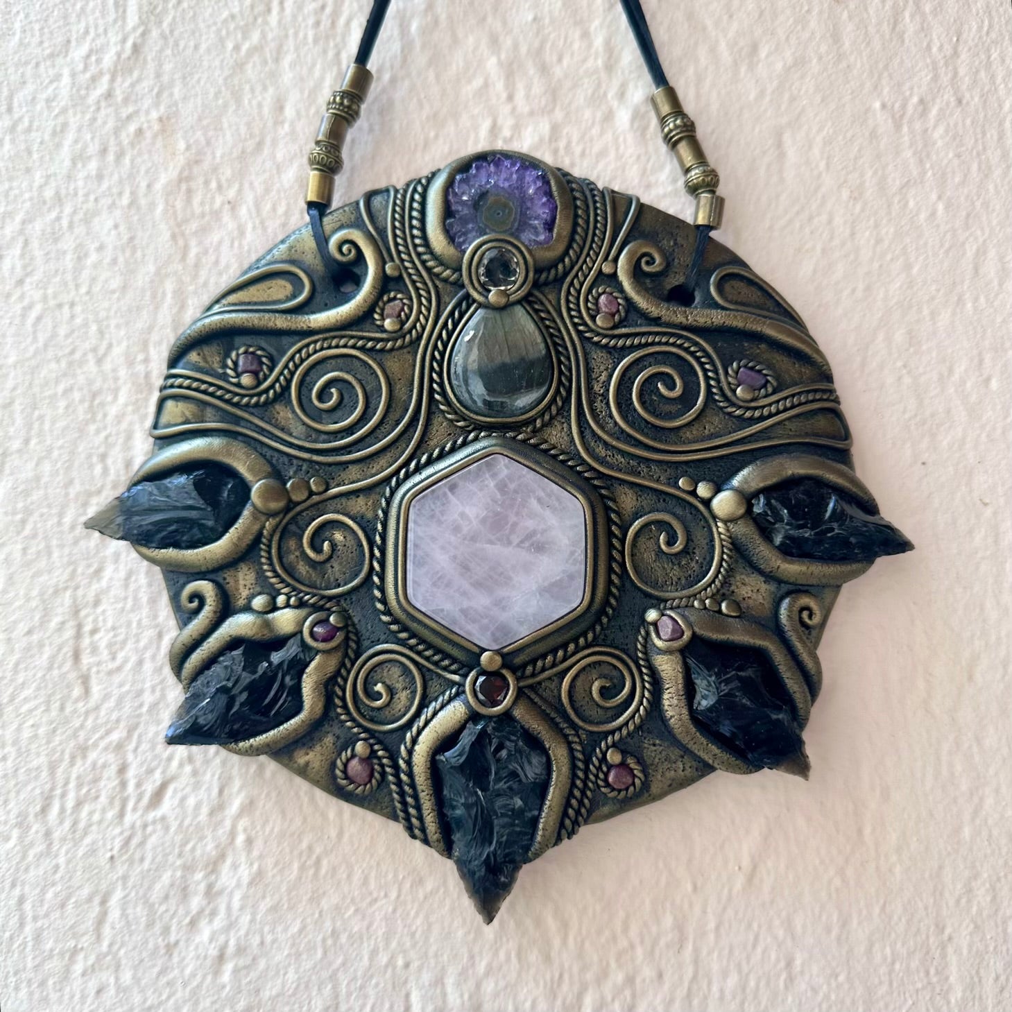 Decorative pendant with intricate designs on a white background