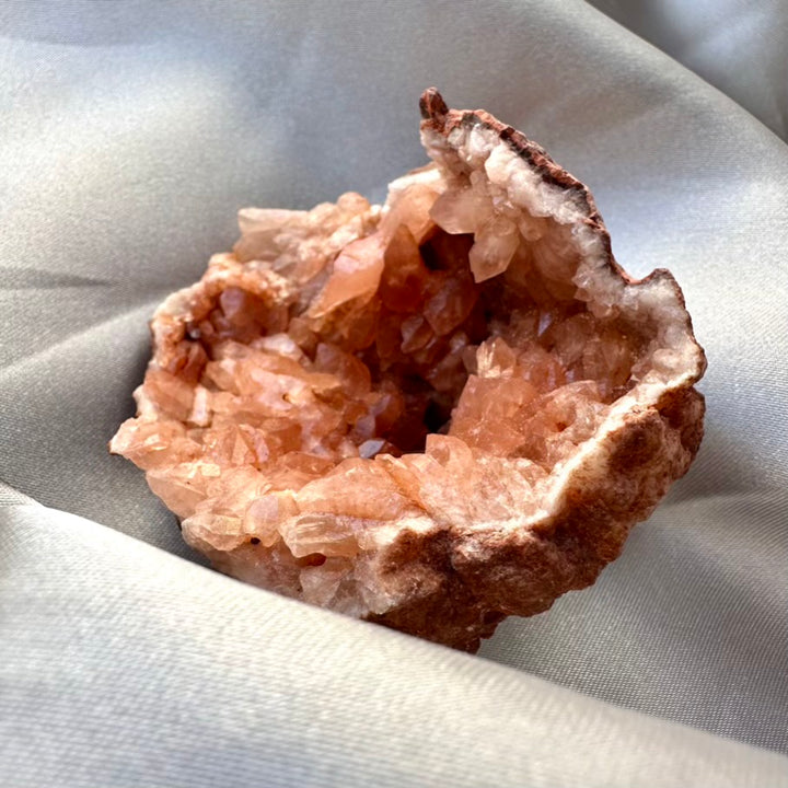 Amethyst Crystal geode on a light gray fabric background