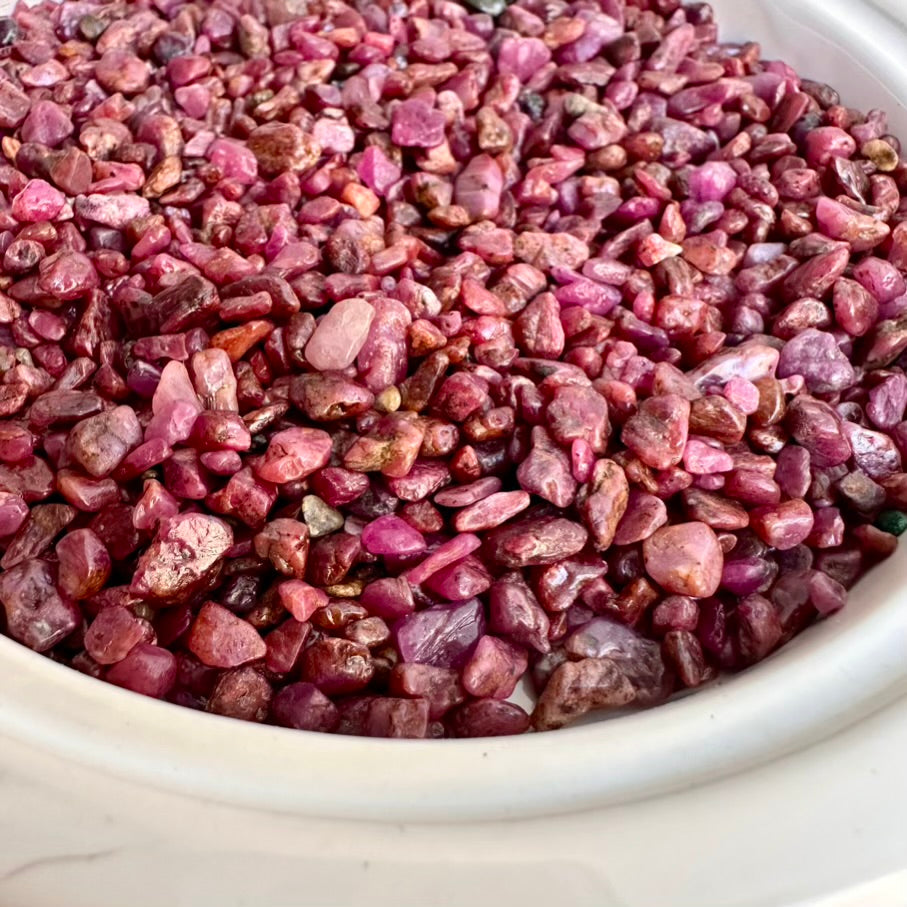 Close-up of pink natural ruby gemstones in white bowl