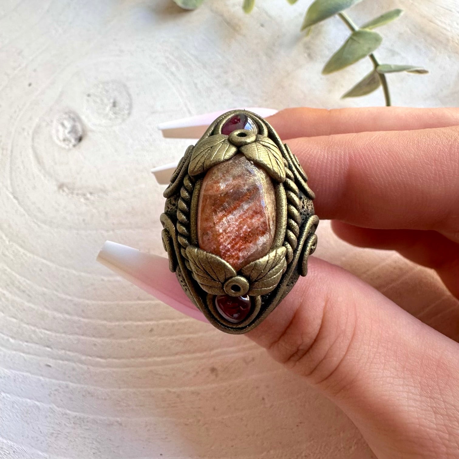 Handmade healing crystal ring featuring glowing Sunstone and Rhodolite Garnet.