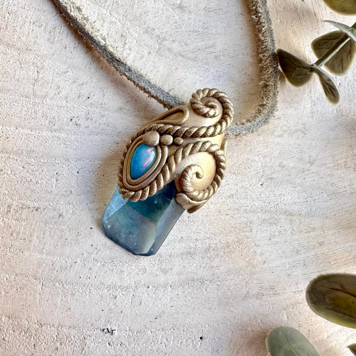 Unique gemstone pendant featuring iridescent Aqua Aura Quartz and glowing blue Ethiopian Opal.