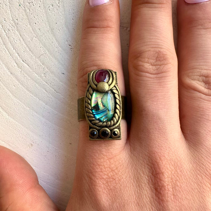One of a kind Abalone ring with colorful iridescent shell, deep red Garnet and blue Sapphire.