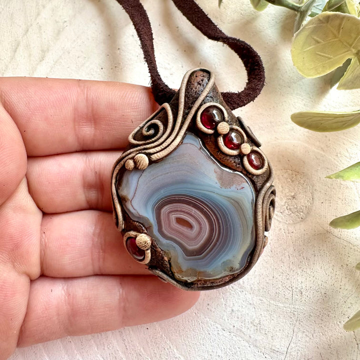 Handmade healing crystal necklace featuring Botswana Agate and Rhodolite Garnet natural stones.
