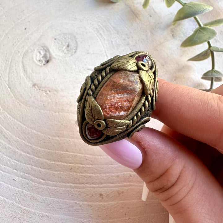 Artisan ring featuring Sunstone and Rhodolite Garnet in a unique handmade setting.