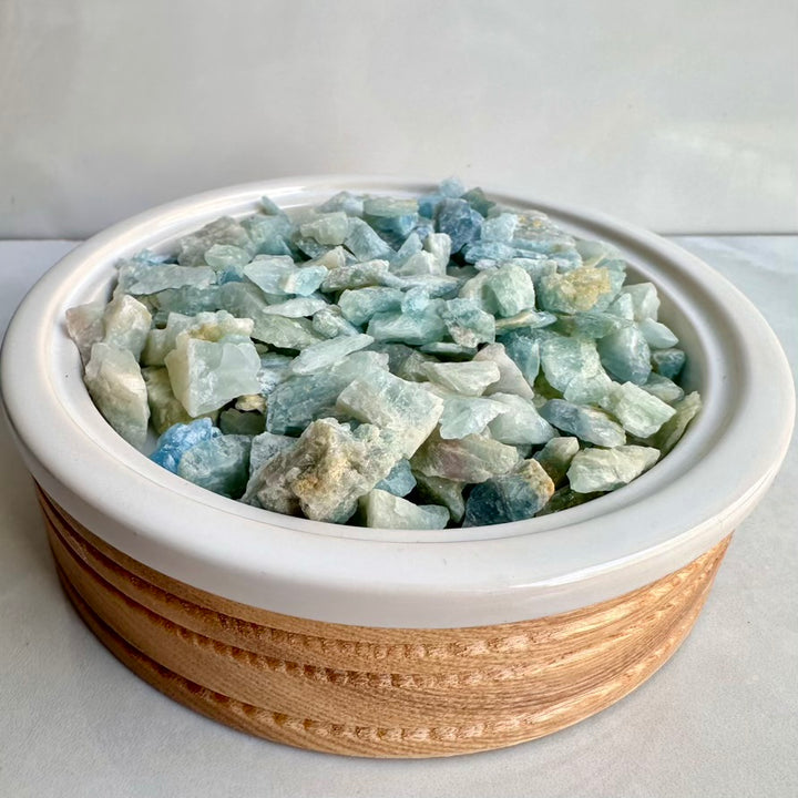 Bowl filled with Aquamarine crystals on a white background