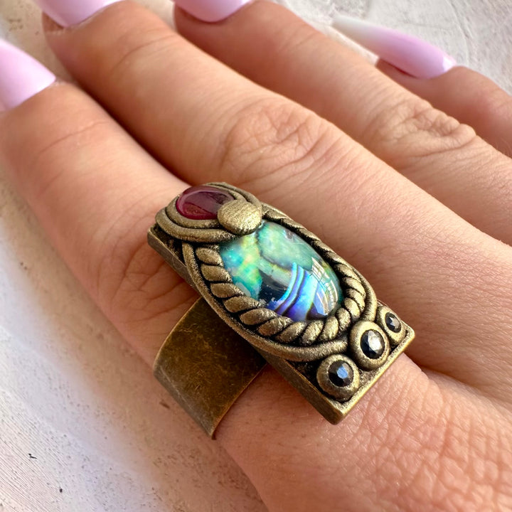 Handmade gemstone ring combining shimmering Abalone Seashell with Rhodolite Garnet and Blue Sapphire.