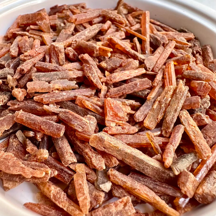 Close-up of orange kyanite stones in a white bowl