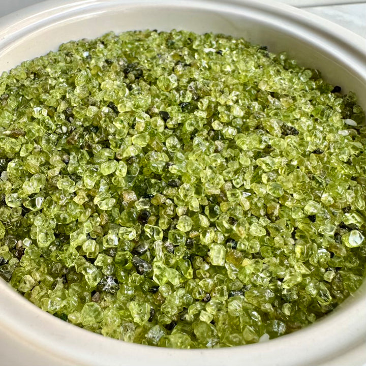 Green Peridot crystals in a white container