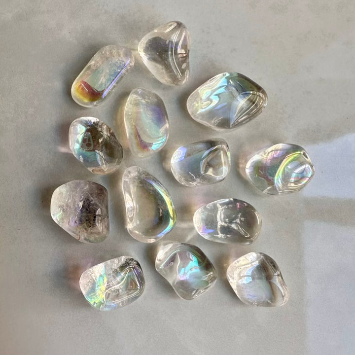 Collection of Polished aura quartz gemstones on a light gray background