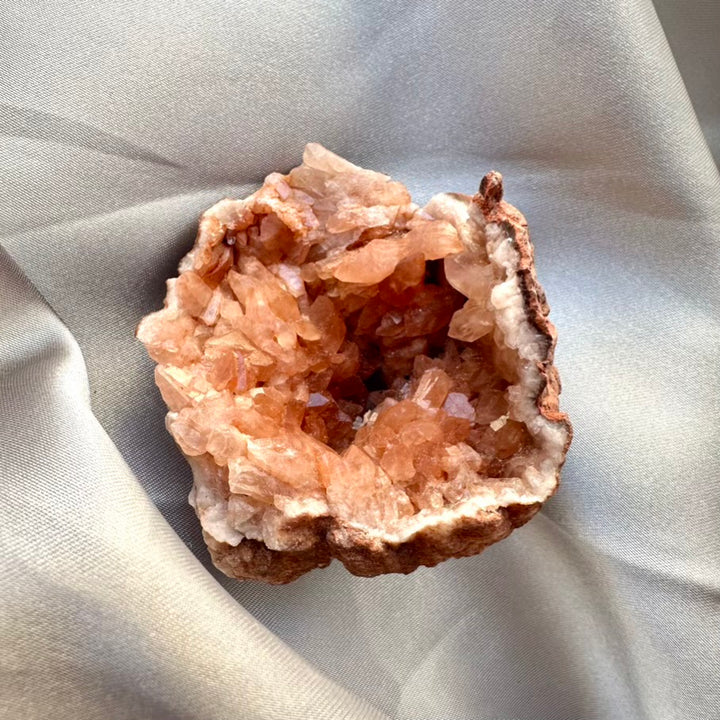 Pink amethyst crystal geode on light gray background