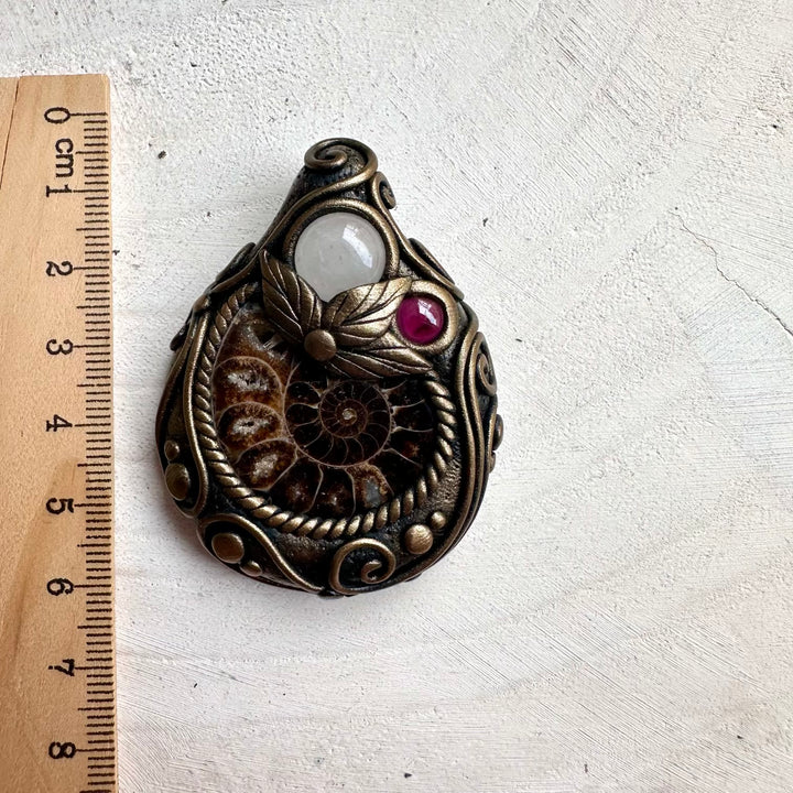 Protection amulet necklace featuring healing crystals Clear Quartz and Rhodolite Garnet with natural Ammonite fossil.
