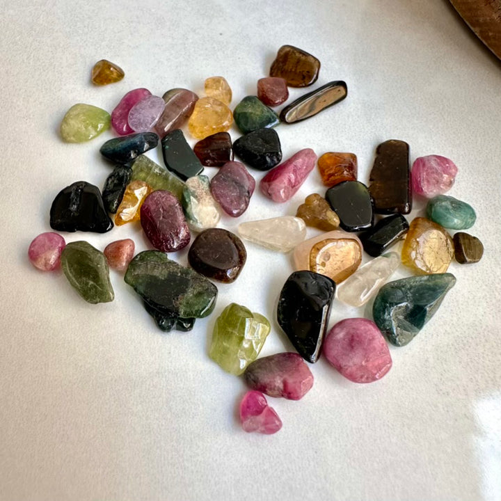 Assorted multicolored gemstones on a white surface