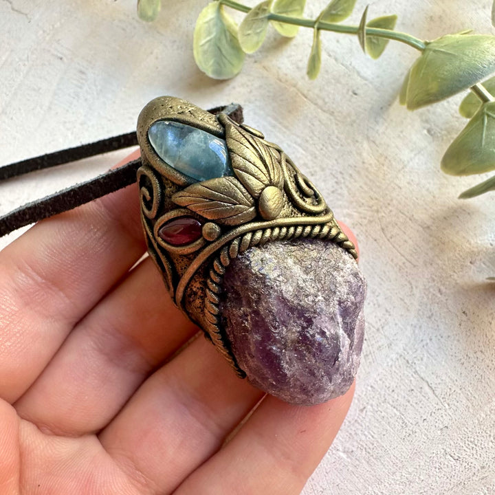 Handmade pendant combining a raw Scapolite crystal with Aquamarine and Rhodolite Garnet.
