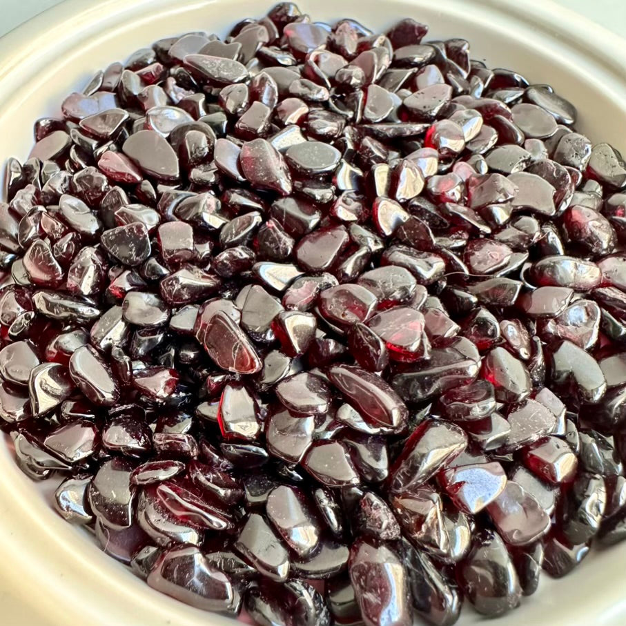 Close-up of red garnet polished stones on a white plate