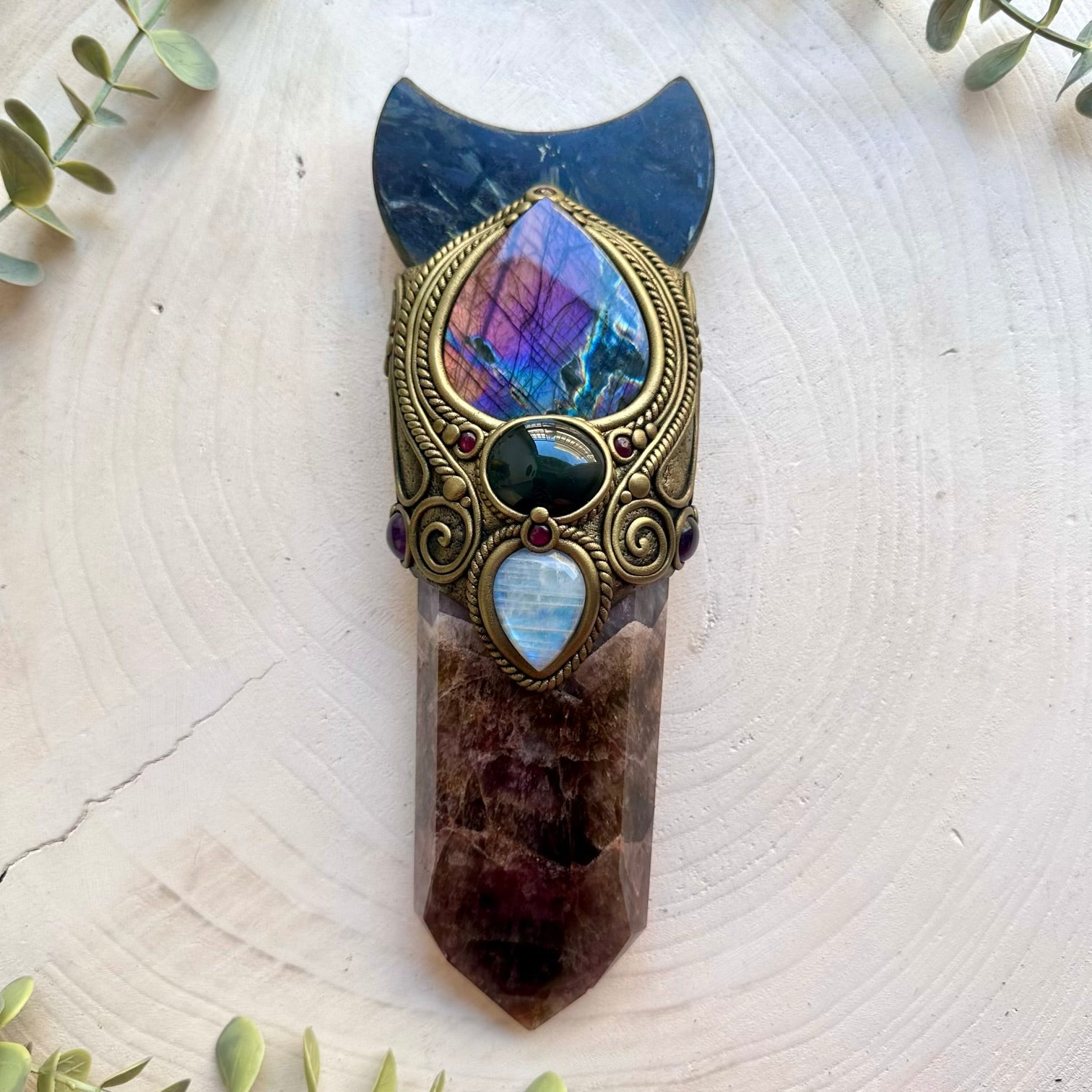 Handmade Super Seven Quartz crystal wand featuring an Astrophyllite Moon, Purple Labradorite, Rainbow Obsidian, Rainbow Moonstone, Amethyst and Rhodolite Garnet, a one of a kind energy and ritual tool designed for manifestation, intuition, protection, emotional healing and spiritual awakening.