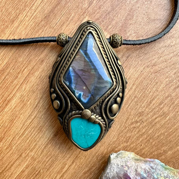 Necklace with decorative pendant featuring a rainbow labradorite stone on a wooden surface