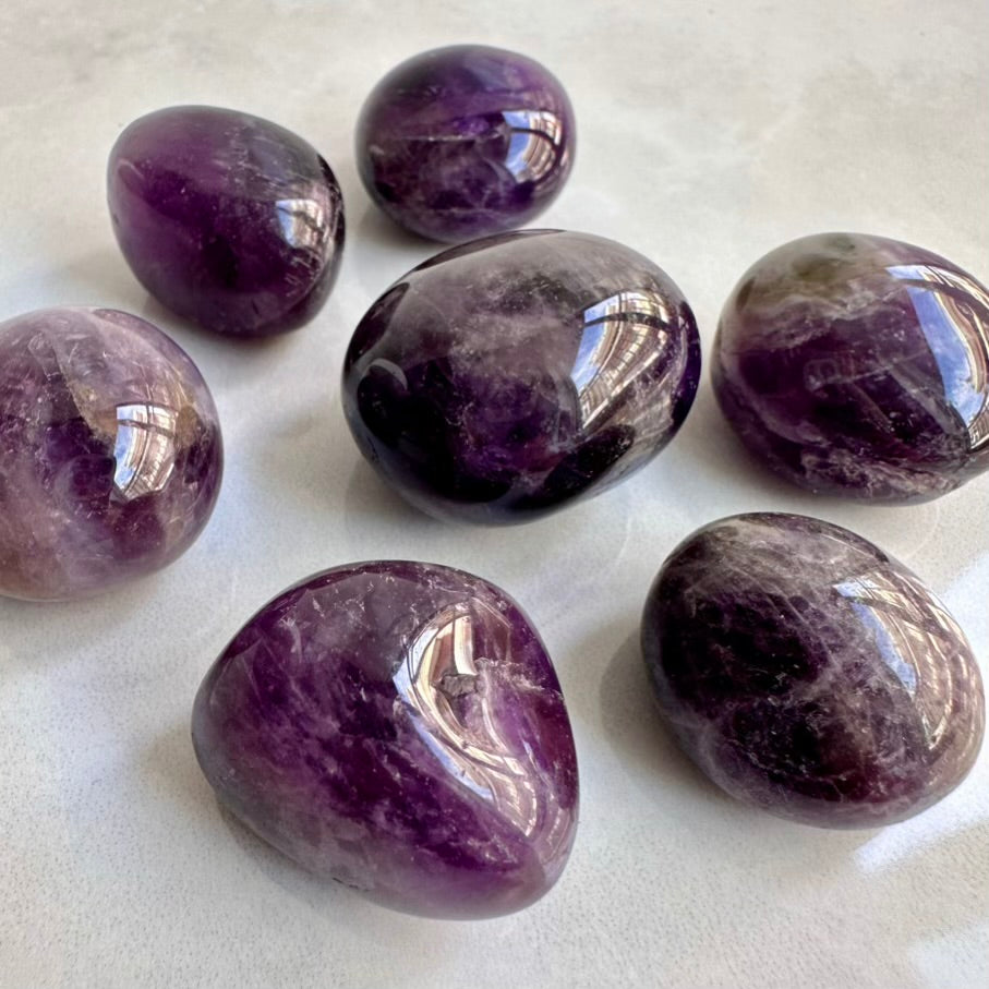 Purple amethyst stones on a white surface
