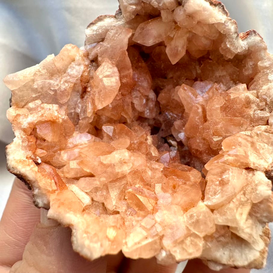 Close-up of an pink amethyst crystal formation held in hand