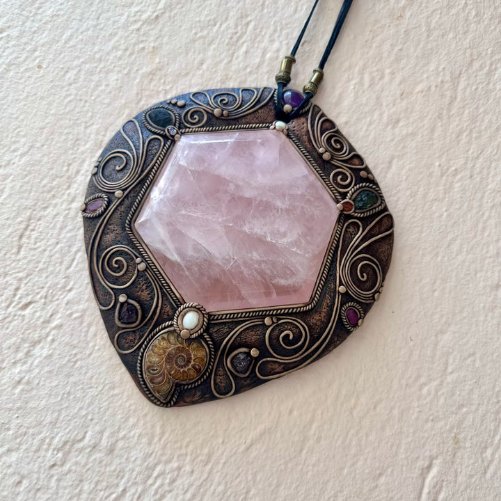 Decorative Crystal pendant with pink stone and intricate claywork on a white background