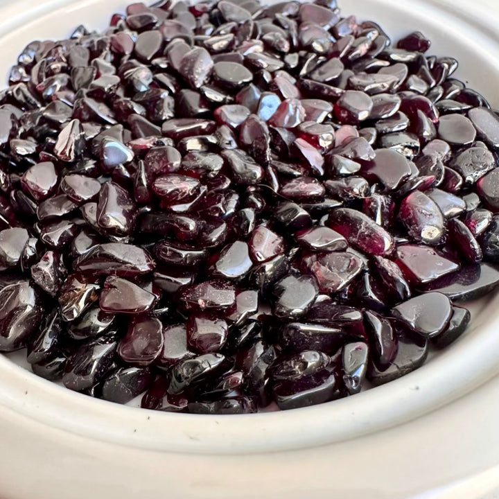 Close-up of dark red garnet gems in a white bowl