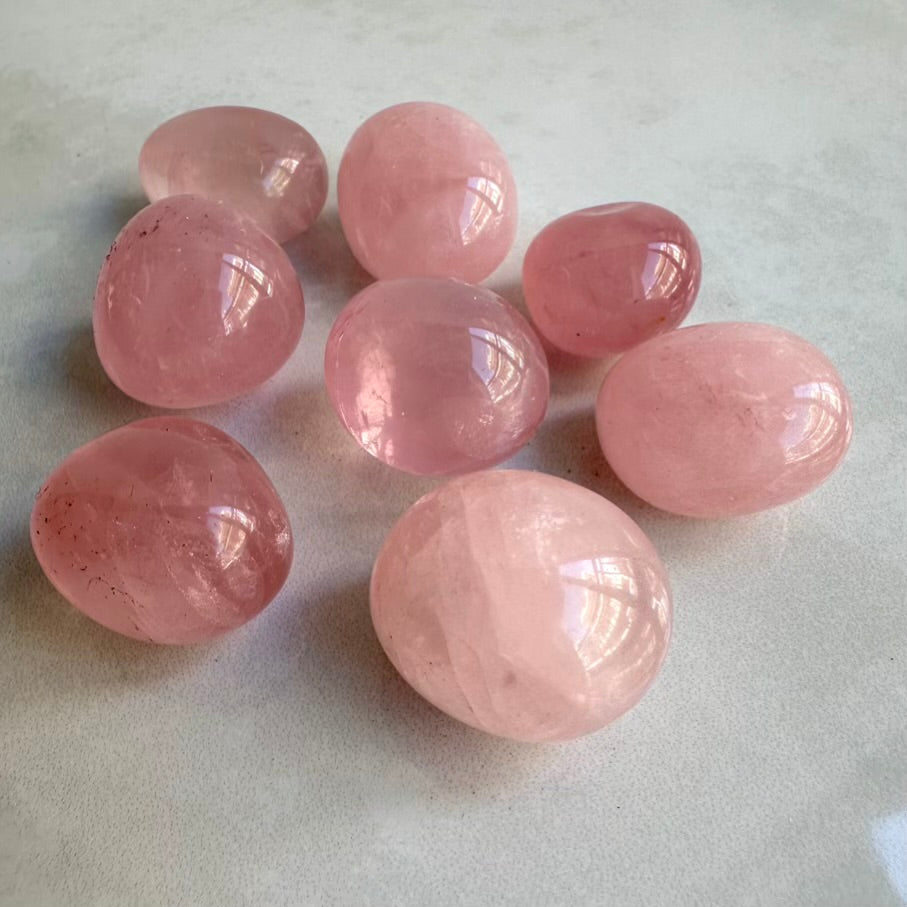 Pink rose quartz crystals on a light gray background