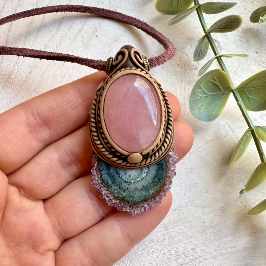 Close up of amethyst stalactite and rose quartz crystal pendant