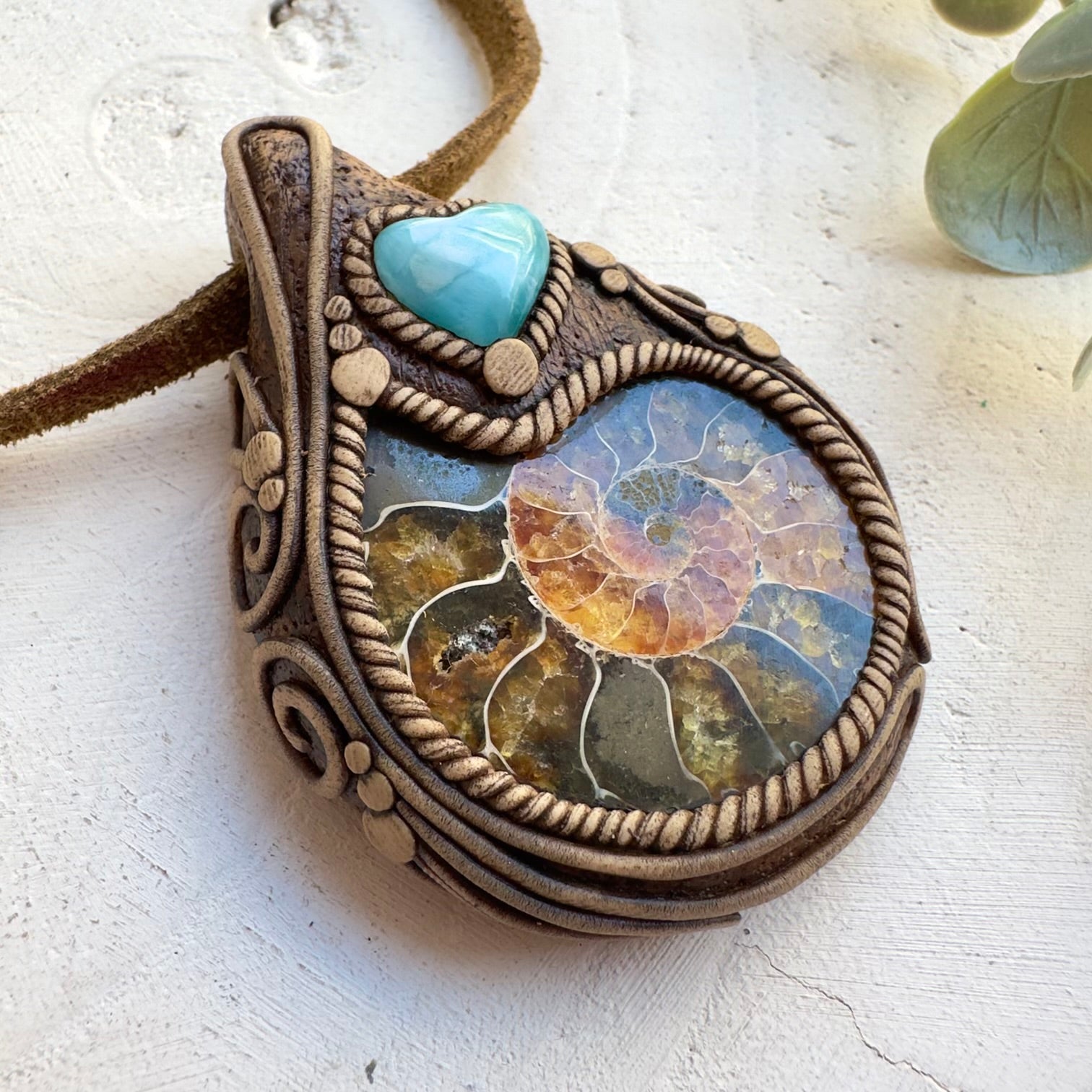 Close up of ammonite fossil and Larimar heart pendant necklace