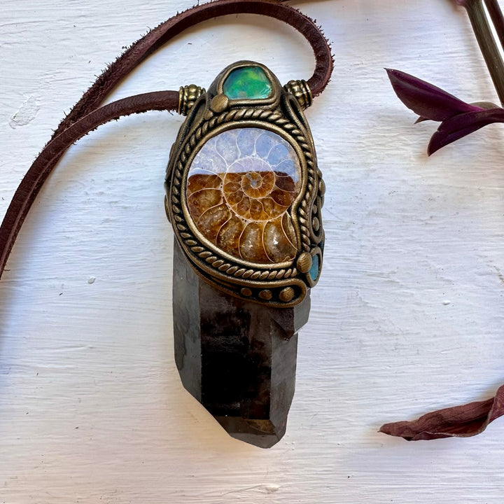 Necklace with a pendant featuring an ammonite fossil on a white surface