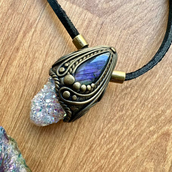 Necklace with gemstone and crystal pendant on a wooden surface