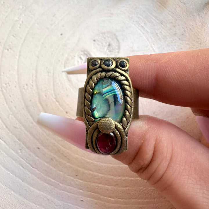 Natural gemstone ring with shimmering Abalone, deep red Garnet and blue Sapphire.