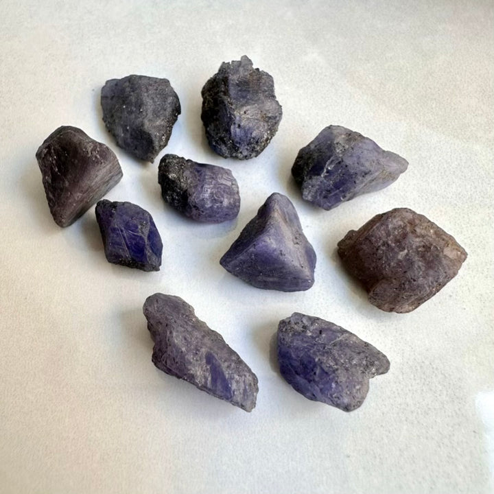 Purple Unpolished Tanzanite crystals on a white background