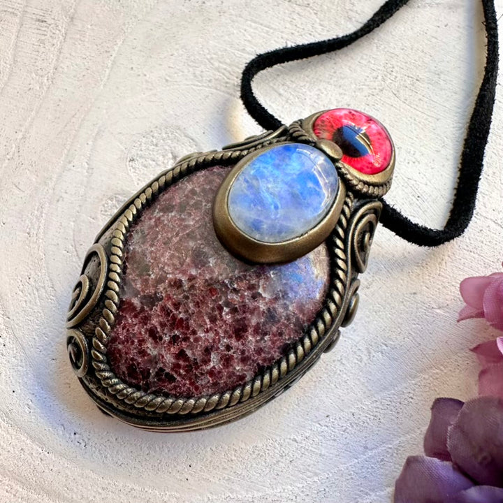 Protective Red Garnet crystal pendant with intuition-boosting Rainbow Moonstone eye amulet, handmade spiritual jewelry tool.