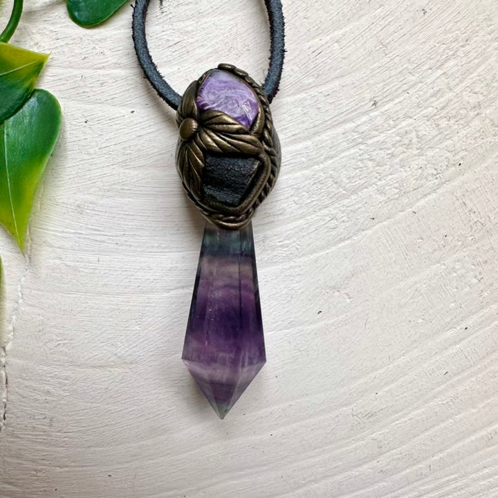 Fluorite point pendant paired with raw Moldavite and Charoite