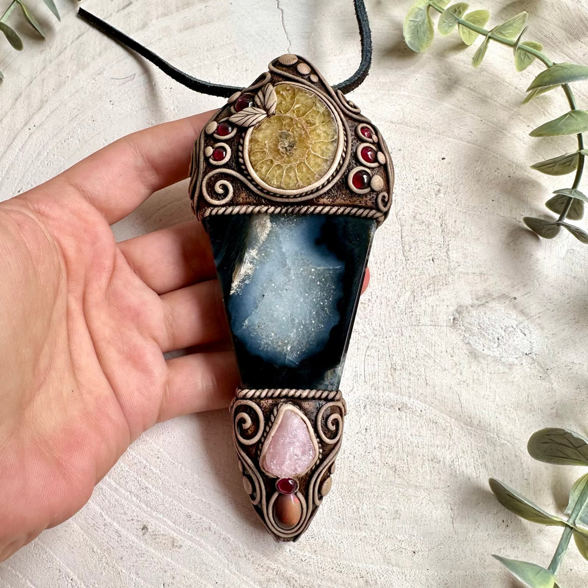 Handmade Agate with Ammonite, Raw Morganite, Ethiopian Opal and Rhodolite Garnet crystal wand / pendant necklace, a one of a kind healing crystal jewelry piece combining earthy Agate and an ancient Ammonite with delicate Morganite, colorful Ethiopian Opal and rich Rhodolite Garnet. This unique spiritual gemstone talisman is inspired by traditional associations of grounding, stability, ancient wisdom, love, compassion, creativity, confidence and transformation.