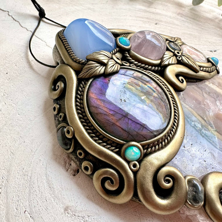Colorful Ethiopian Opal and Clear Topaz add luminous accents to this handmade Amethyst and Labradorite gemstone wall art.