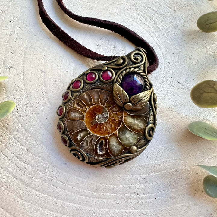 Artisan gemstone pendant combining Ammonite with Amethyst and Rhodolite Garnet in a unique design.