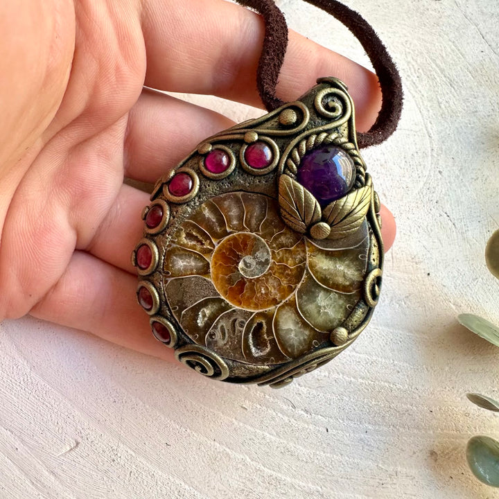 Handmade Ammonite healing crystal necklace featuring Amethyst and Rhodolite Garnet, a one of a kind gemstone pendant combining an ancient natural fossil with rich purple and deep red crystals.