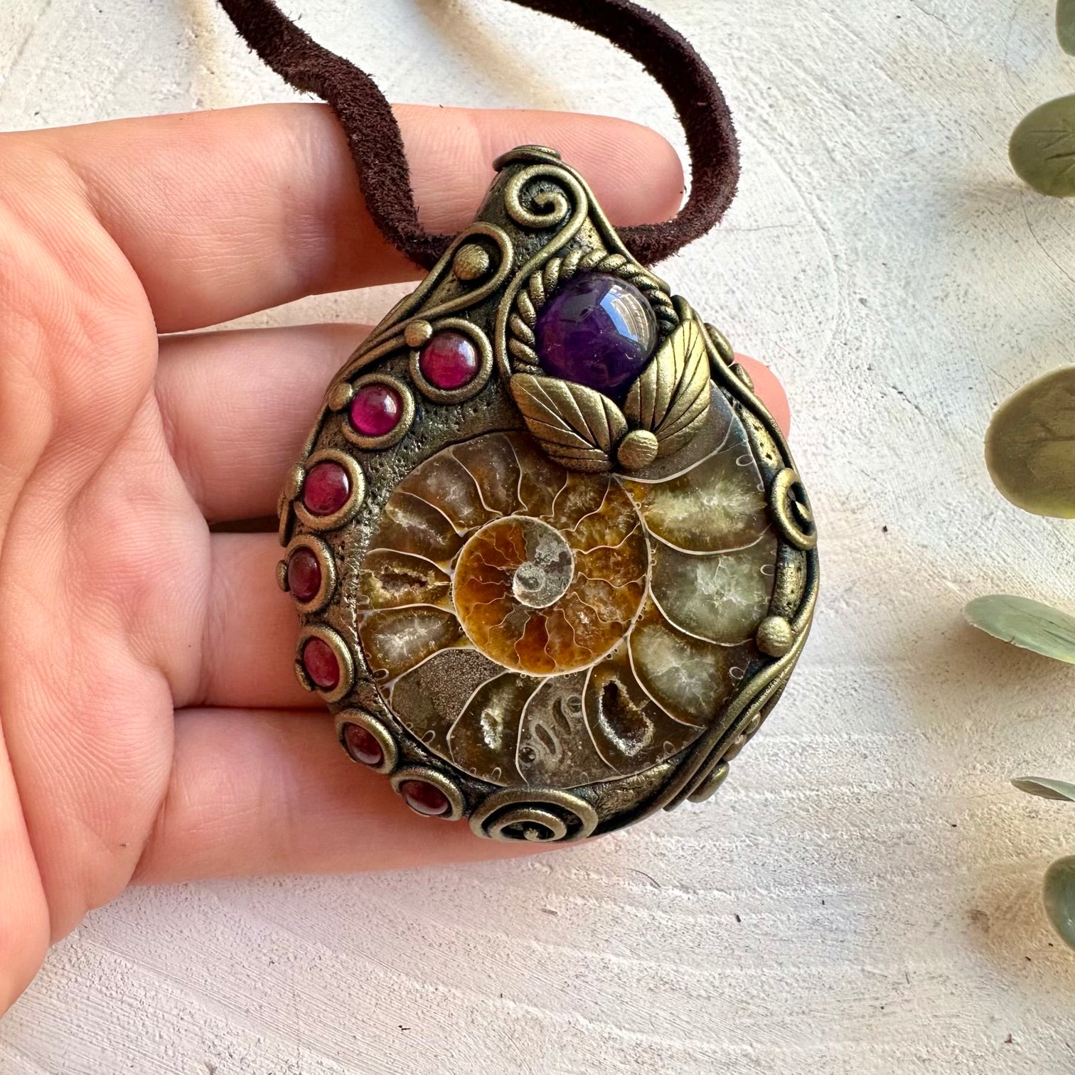 Handmade gemstone necklace combining an Ammonite fossil with Amethyst and Rhodolite Garnet.