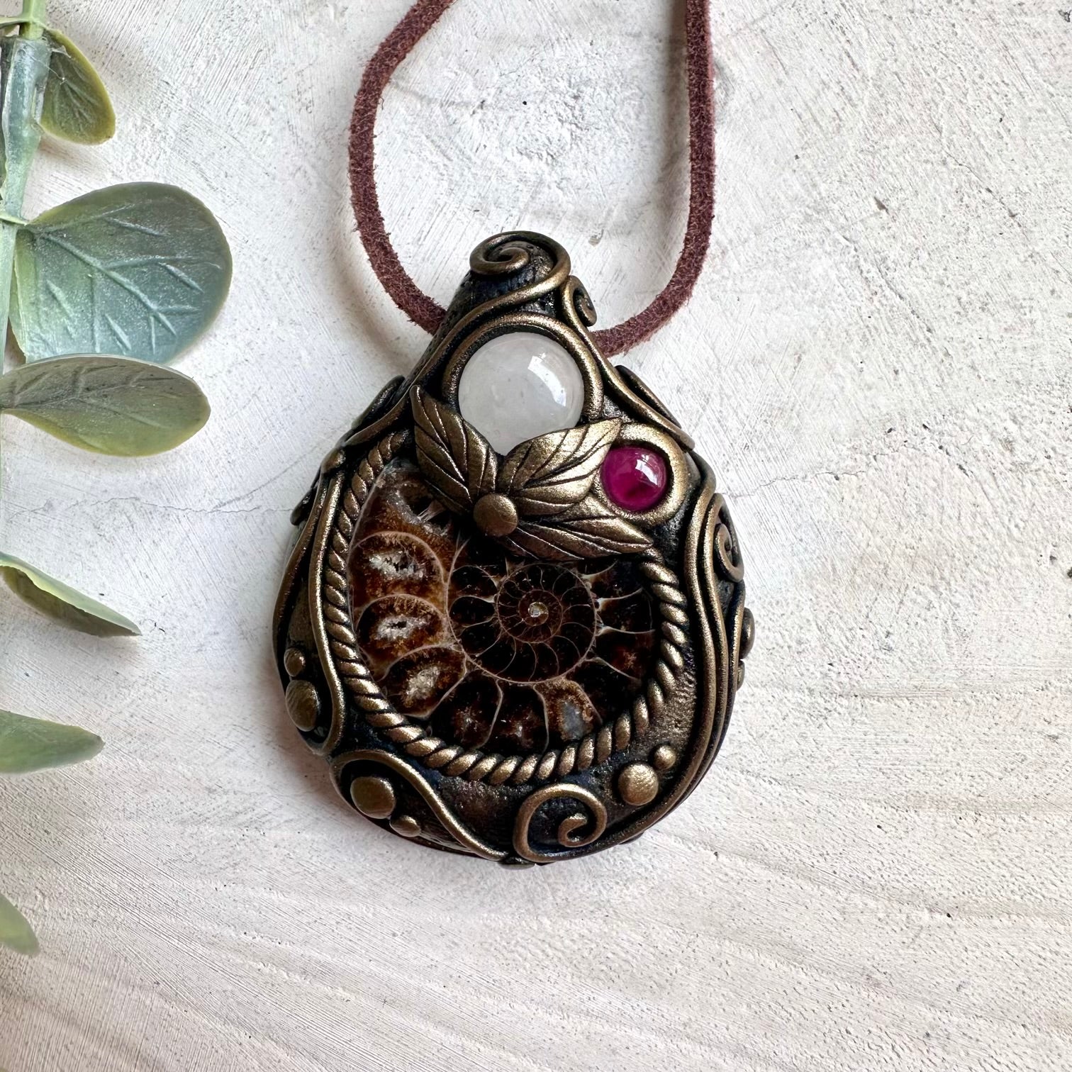 Handmade Ammonite, Clear Quartz, and Rhodolite Garnet healing crystal necklace with spiritual gemstone pendant.