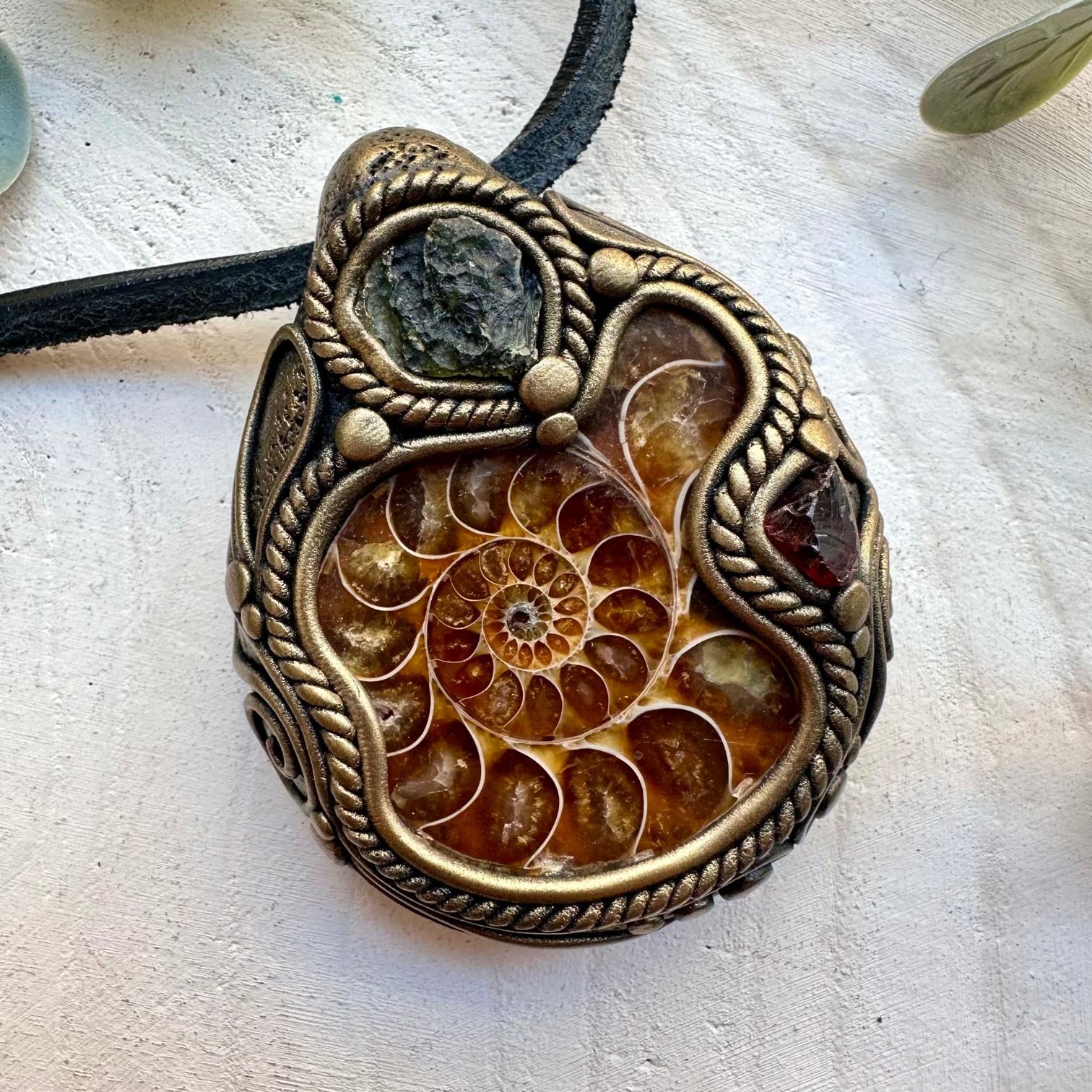 Natural ammonite paired with moldavite and red garnet