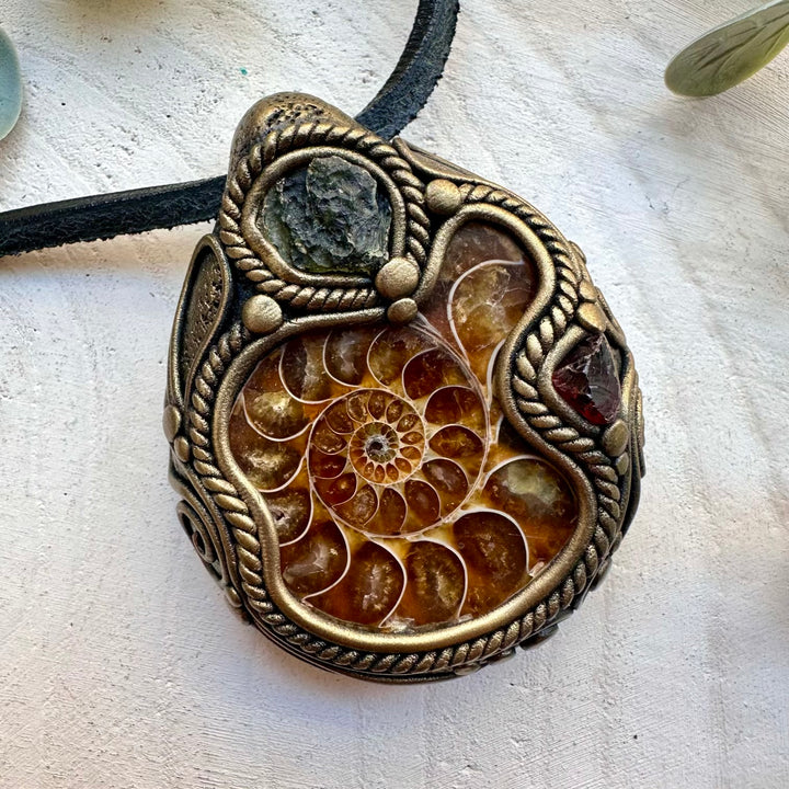 Natural ammonite paired with moldavite and red garnet