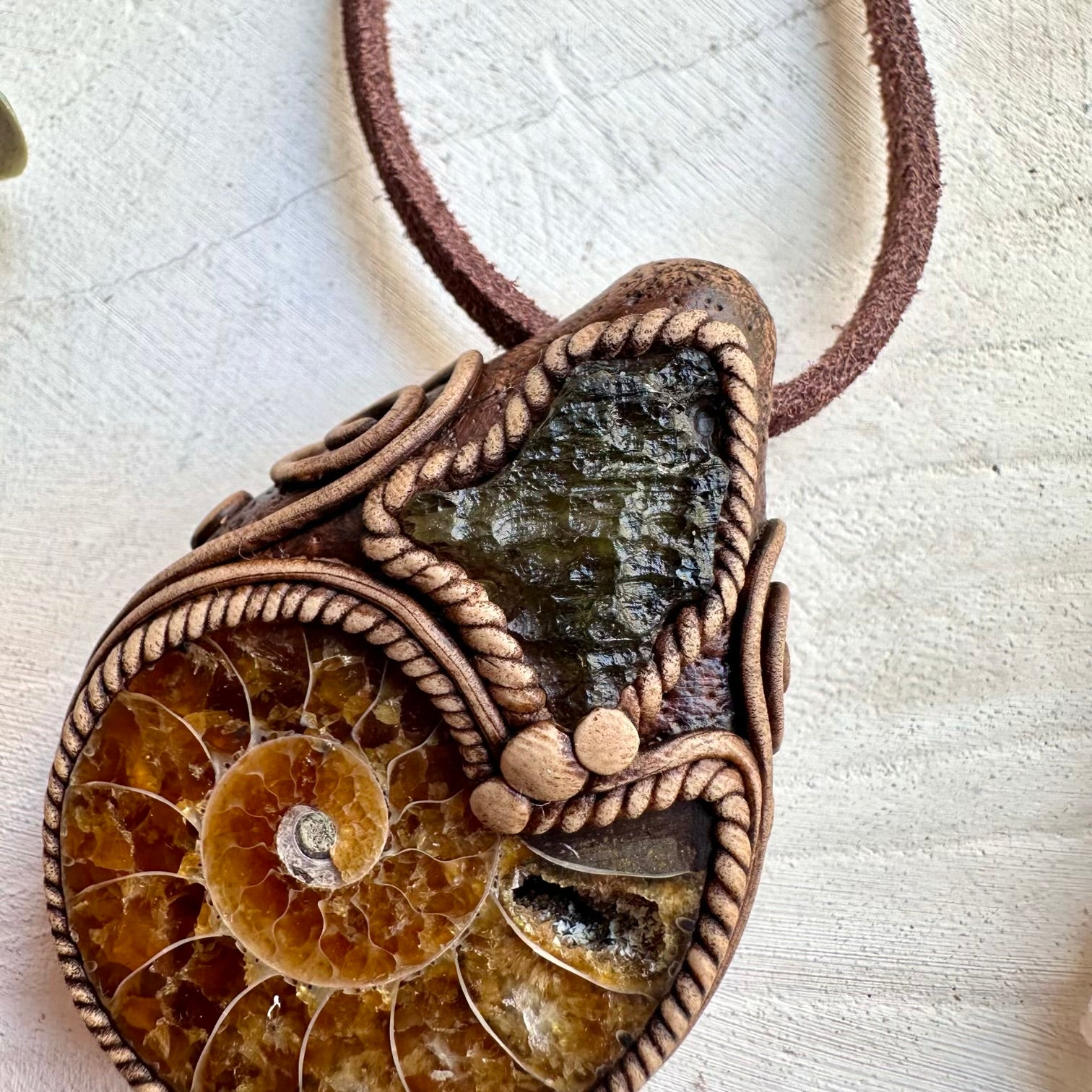 Raw moldavite paired with ammonite fossil in a necklace