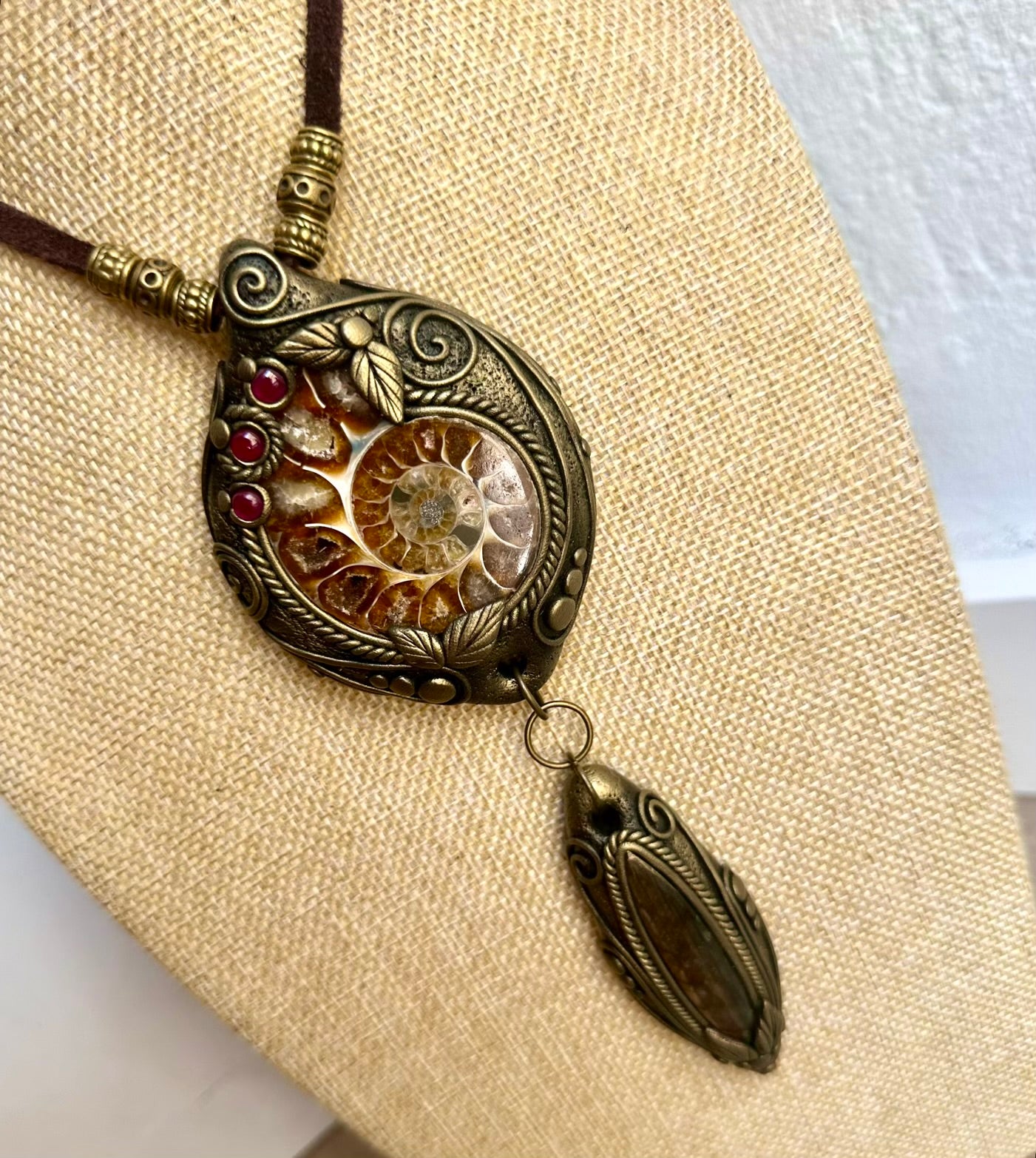 Handmade statement necklace featuring a natural Ammonite with Labradorite and Rhodolite Garnet gemstones.