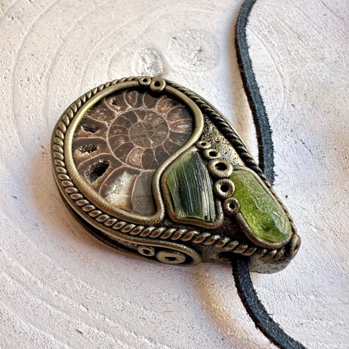Unisex handmade pendant necklace showcasing the spiral pattern of Ammonite with Peridot and Moldavite accents.