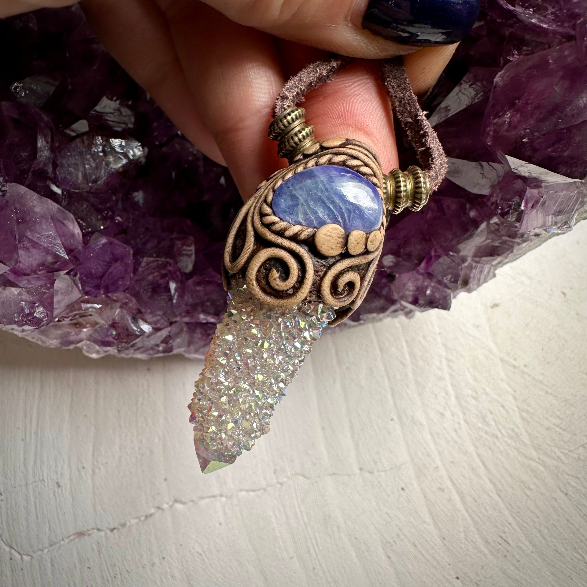 Angel Aura Spirit Quartz and Tanzanite Necklace with clay pendant and adjustable leather, featured on amethyst background.